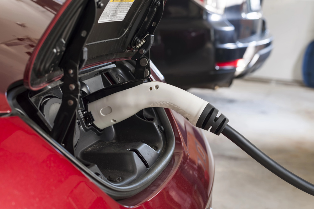 Electric car charging with a white charging cable plugged into the port in Centennial CO